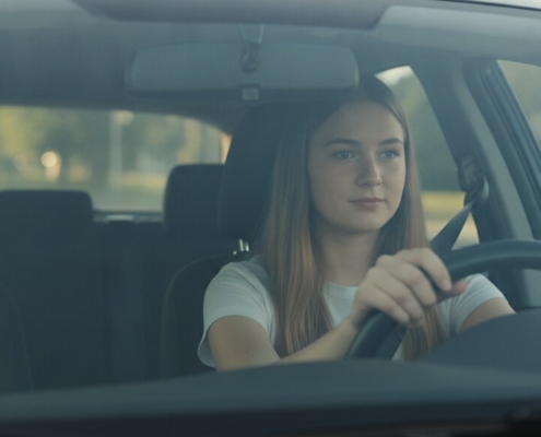 Jonge leerling met handen aan het stuur tijdens een rijles, voorkomt veelgemaakte fouten