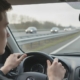 Jonge bestuurder die invoegt op de snelweg en in de linkerspiegel kijkt