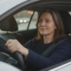 Volwassen leerling haalt rijbewijs op latere leeftijd, met beide handen aan het stuur in de lesauto