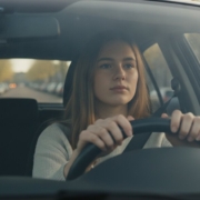 Jonge vrouw haalt rustig adem achter het stuur van de lesauto voor haar faalangstexamen bij het CBR