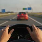 Handen aan het stuur met veilige afstand houden tot de auto op de snelweg
