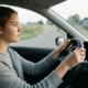 Leerling met beide handen aan het stuur op een rustige weg tijdens de rijles