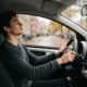 Jonge bestuurder haalt diep adem achter het stuur van de lesauto voor zijn herexamen na gezakt rijexamen